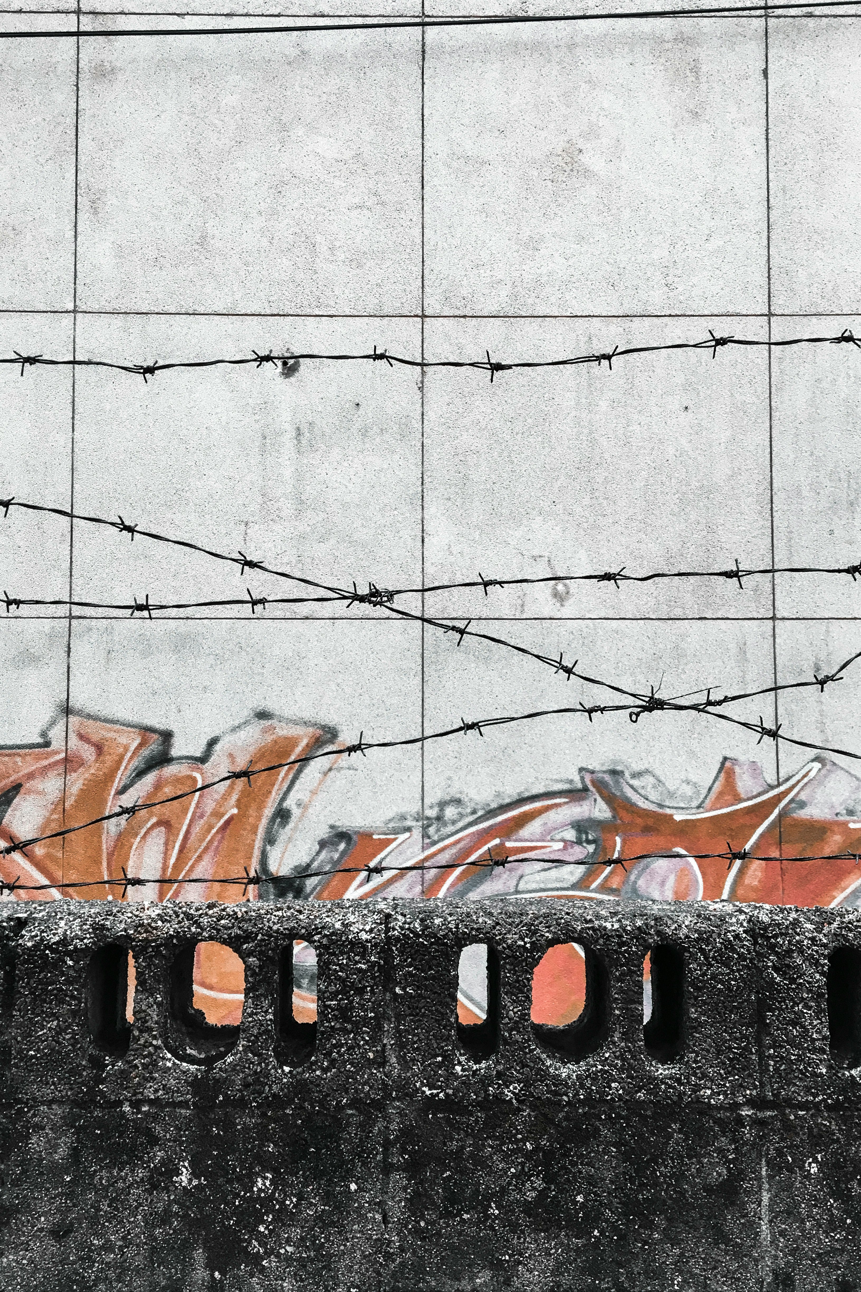 white concrete wall with orange and red graffiti